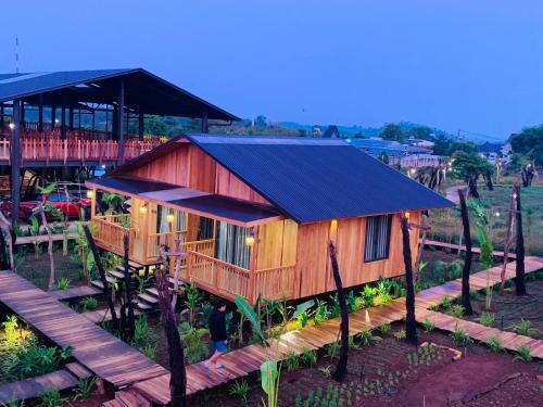 ein Holzhaus mit einer Terrasse und einem Restaurant in der Unterkunft Cái Gùi Tà Đùng in Biđong