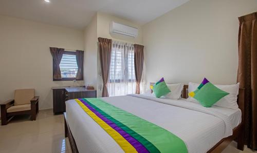 Postel nebo postele na pokoji v ubytování Treebo Samanvaya Retreat, Mysore