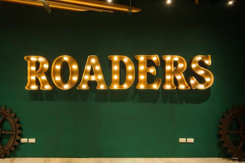 Un'insegna al neon che dice robados su un muro verde. di Roaders Hotel - Zhonghua a Taipei