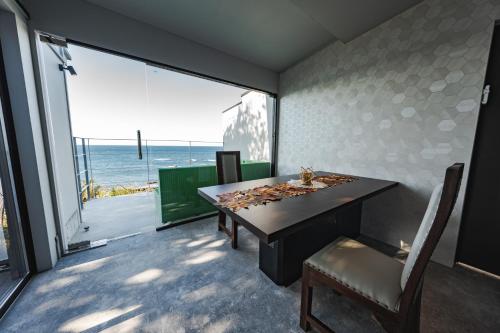 a dining room with a table and a view of the ocean at XYZ speciale in Shirahama