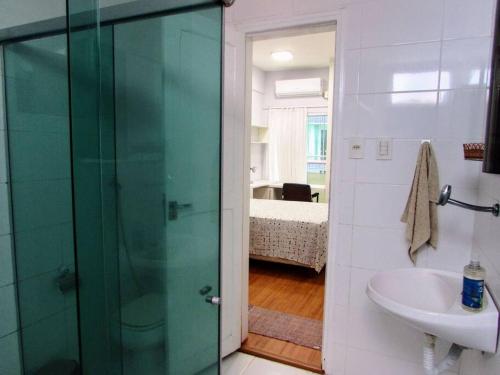 a bathroom with a glass shower and a sink at Studio La Amazon in Belém