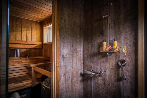 ein Bad mit einer Dusche und Holzwänden in der Unterkunft Hotel & Spa Resort Järvisydän in Rantasalmi