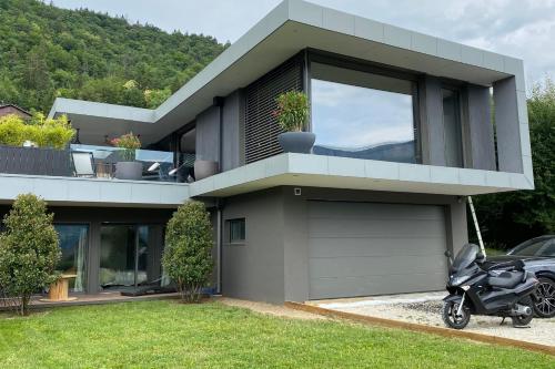 a house with a motorcycle parked in front of it at Villa Juco - 4 Bedroom Villa Pool Sauna - Lake View in Sévrier