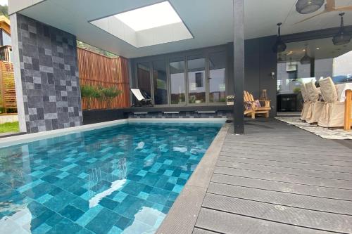 a swimming pool with blue tiles on the floor at Villa Juco - 4 Bedroom Villa Pool Sauna - Lake View in Sévrier