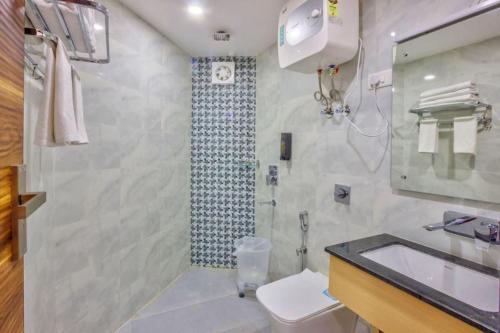 a bathroom with a sink and a toilet and a shower at Astra Luxury Rooms and Cafe in Varanasi