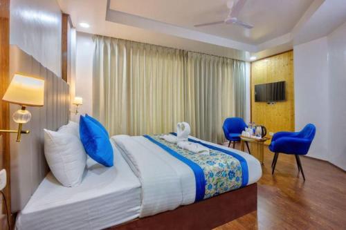 a hotel room with a large bed with blue pillows at Astra Luxury Rooms and Cafe in Varanasi