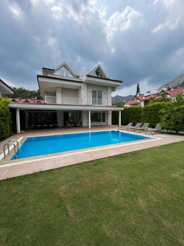 a large house with a swimming pool in the yard at blue depth villa in Fethiye