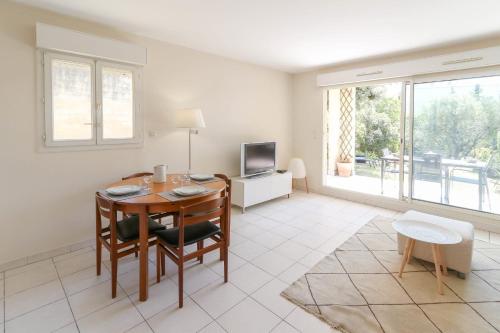 un salon avec une table et une télévision dans l'établissement Charming & bright flat with AC Garden 300m and Closed Garage - BENAKEY, à Cannes
