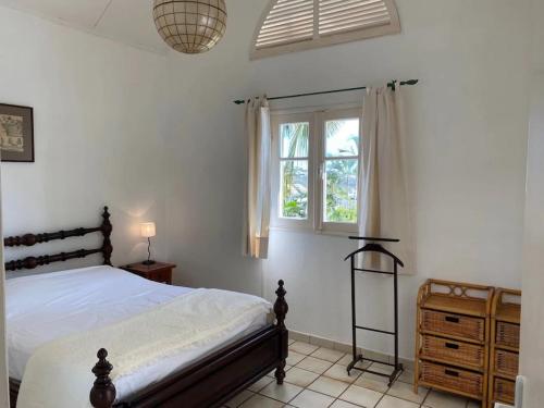 un dormitorio con una cama y una ventana en Villa Baleine Bleue piscine&vue, en Saint-Paul