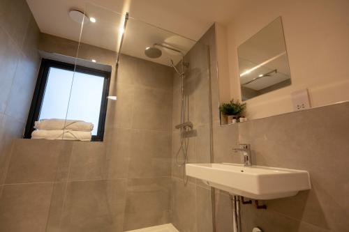 a bathroom with a sink and a shower with a mirror at Forest Corner Luxury Apartment with Hot Tub in North Ballachulish