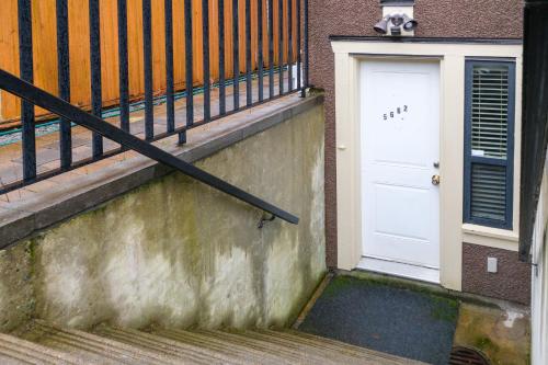 una scala con porta bianca e ringhiera di Oakridge Cozy Guesthouse a Vancouver