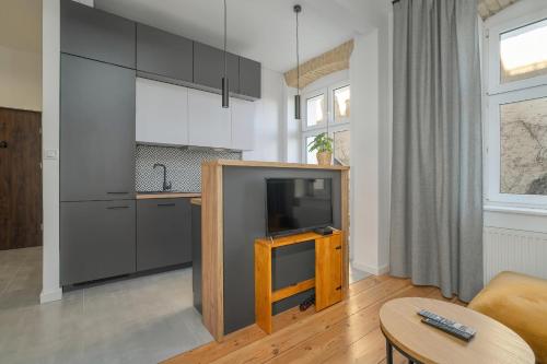 een woonkamer met een tv en een keuken bij Elegant Apartment near to the Centre of Poznań by Rent like home in Poznań