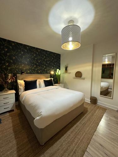 a bedroom with a large white bed and a lamp at Blush Jungle in Dublin