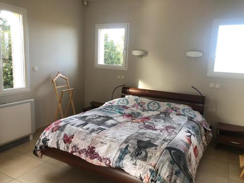 ein Schlafzimmer mit einem Bett mit einer Decke darauf in der Unterkunft Maison climatisée piscine salle de sport 8/9 pers. in Monteux