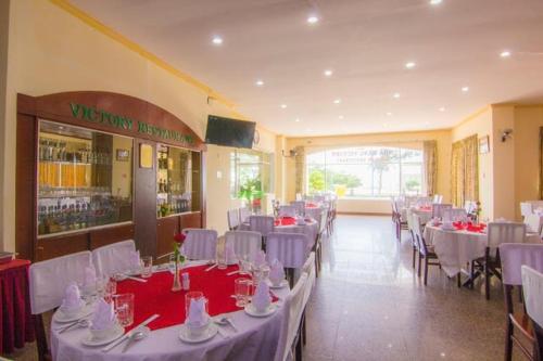 a banquet hall with white tables and white chairs at Victory Hotel Old Wing in Vung Tau