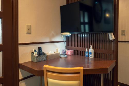 a table in a hotel room with a lamp and a desk at Grand Hotel Narita Airport in Akaike
