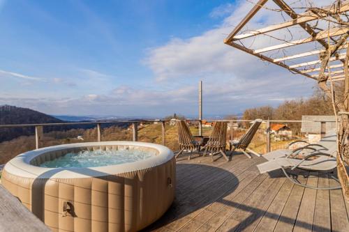 - un bain à remous sur une terrasse avec une table et des chaises dans l'établissement Vineyard Cottage Sunny Hill - Happy Rentals, à Mirna