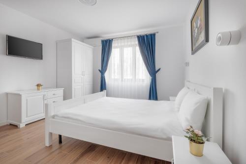 - une chambre blanche avec un lit et une fenêtre dans l'établissement Thermalis Grove Private House, à Băile Felix