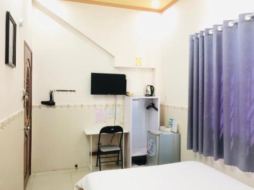 um quarto com uma cama, uma secretária e uma televisão em Huy Hoàng Motel - Cần Thơ em Can Tho