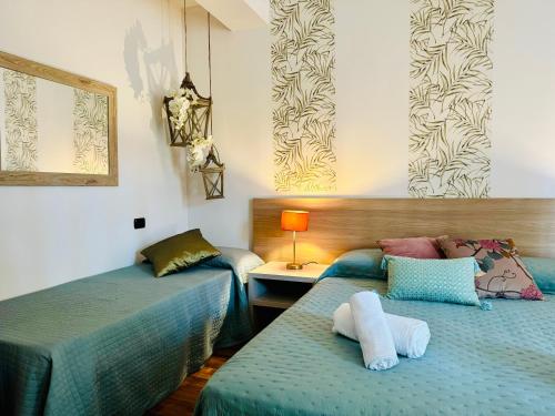 um quarto com duas camas e uma mesa com um candeeiro em WELCOME TRAVELLER FRIDA'S ROOMs em Caprino Veronese