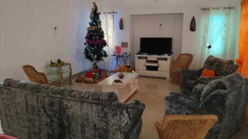 una sala de estar con un árbol de Navidad en la esquina en Paradise Villa, en Pūrnānkuppam