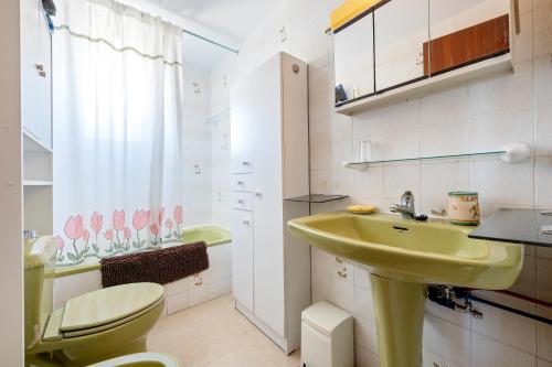 ein Badezimmer mit einem grünen Waschbecken und einem WC in der Unterkunft Apartament 1a linea in Miami Platja