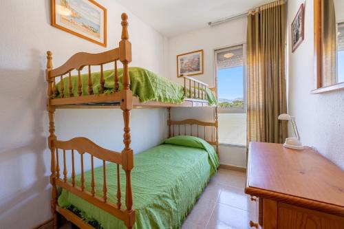 ein Schlafzimmer mit einem Etagenbett und einem Schreibtisch in der Unterkunft Apartament 1a linea in Miami Platja