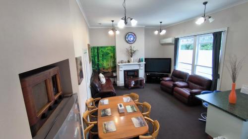 a living room with a table and a couch at City Centre Superior Villa 3 large Double bedrooms in Christchurch