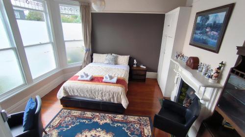 a small bedroom with a bed and a fireplace at City Centre Superior Villa 3 large Double bedrooms in Christchurch