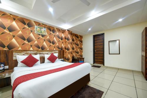 1 dormitorio con 1 cama blanca grande con almohadas rojas en Empire inn Suites Hotel Near Delhi Airport, en Nueva Delhi