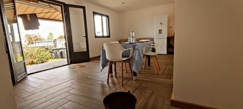 a dining room with a table and chairs and a kitchen at Villa la fournaise in Le Tampon