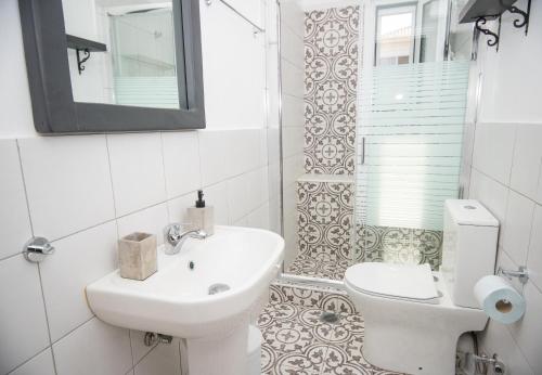 La salle de bains est pourvue d'un lavabo, de toilettes et d'un miroir. dans l'établissement Han’s Maisonette, à Porto Heli