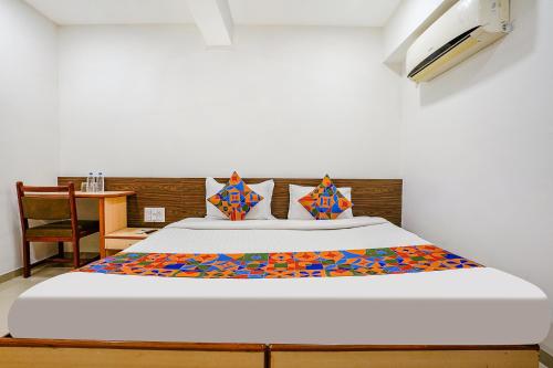 a bedroom with a large white bed with at FabHotel RVG, Alkapuri Vadodara in Vadodara
