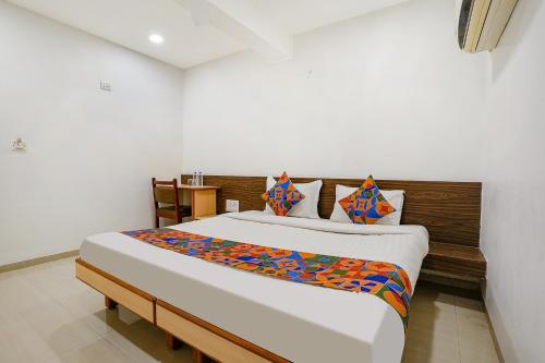 a bedroom with a large bed in a room at FabHotel RVG, Alkapuri Vadodara in Vadodara