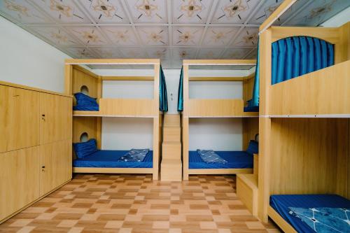 a room with three bunk beds and a ceiling at Windy Homestay in Cat Ba