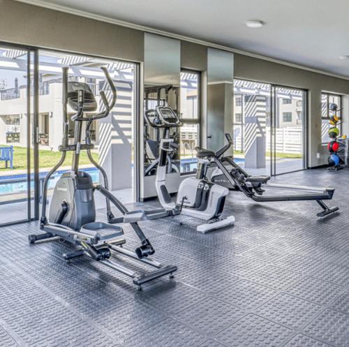 a gym with three treadmills and cardio machines at Tocara Lifestyle Estate: Fourways in Johannesburg