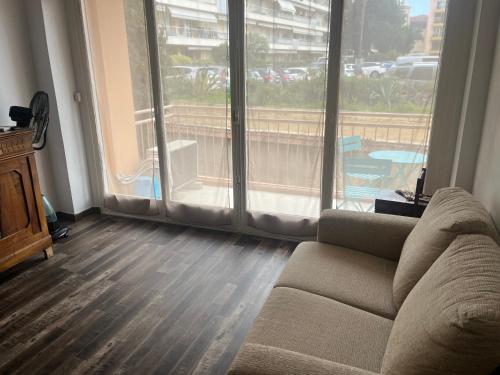 un salon avec un canapé et une grande fenêtre dans l'établissement Appartement proche gare routière, à Menton