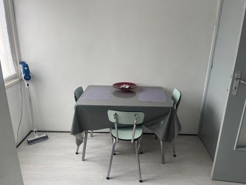 - une table avec des chaises et un bol en haut dans l'établissement Appartement proche gare routière, à Menton