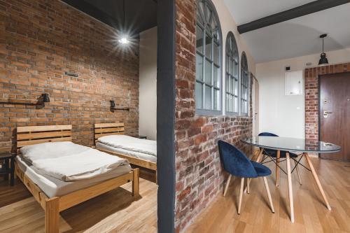 sypialnia z łóżkiem, stołem i ceglaną ścianą w obiekcie Aparthotel Stara Przędzalnia w mieście Żyrardów