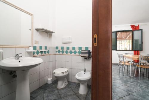 a bathroom with a sink and a toilet and a table at Mare e natura in Posada