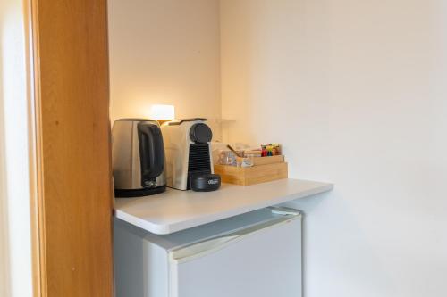 a room with a counter with a microwave and a tv at Alpine Rock B&B in Te Anau