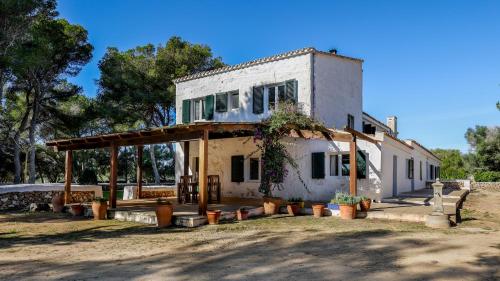 una casa con un porche con macetas delante de ella en Son Mestres de Baix, en Cala Galdana