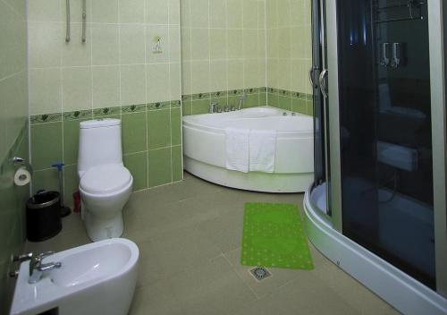 a bathroom with a tub and a toilet and a sink at ORIYO DUSHANBE HOTEL in Dushanbe