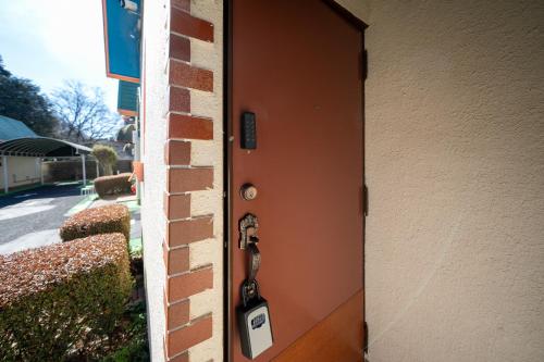 a door with a phone hanging on the side of a building at Grand Hotel Narita Airport in Akaike
