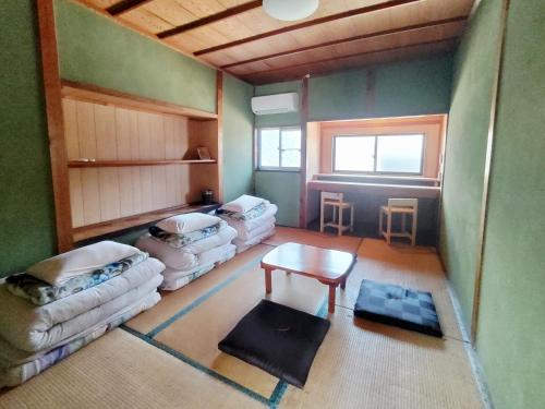 Pokój z 3 kanapami i stołem w obiekcie Amino Guesthouse Bench w mieście Kyotango