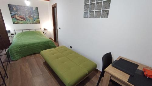 Al Castello في مورانو كالابرو: غرفة نوم بسرير اخضر وطاولة