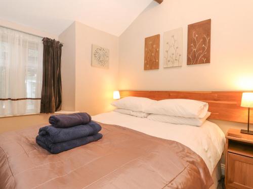 1 dormitorio con 1 cama con 2 almohadas en Myrtle Cottage en Windermere
