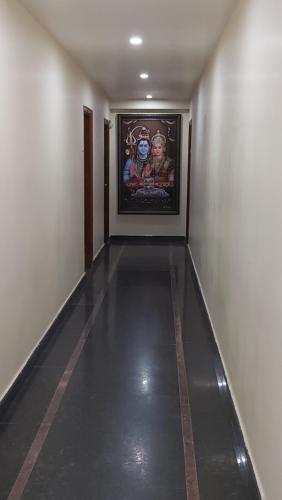 an empty hallway with a painting on the wall at HOTEL KSR GRANDs in Srikalahasti