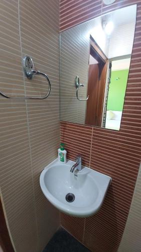 a bathroom with a sink and a mirror at HOTEL KSR GRANDs in Srikalahasti
