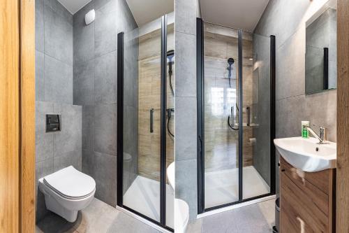 W łazience znajduje się prysznic, toaleta i umywalka. w obiekcie SuperApart Edwarda Habicha 7 w Warszawie